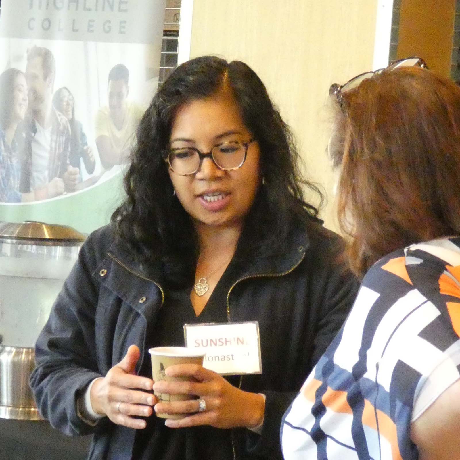 Woman of color speaking to another woman who is listening intently