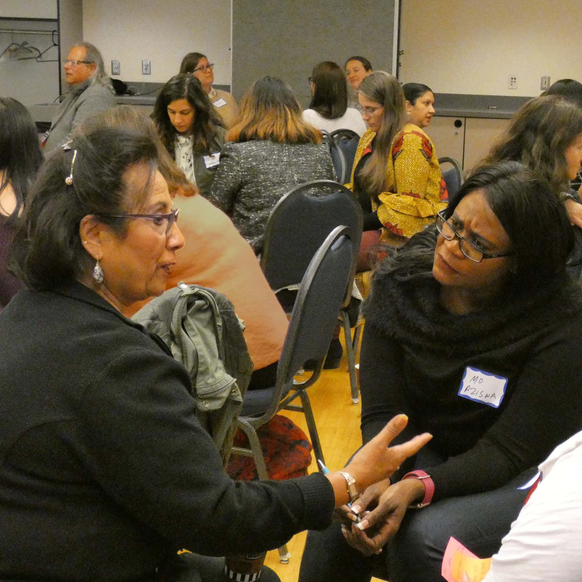 two people focusing on their conversation in a crowded room